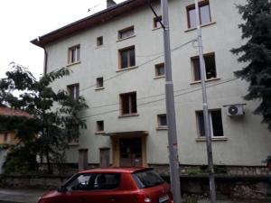 a red car parked in front of a building at Apartment ILIEVI in Pleven