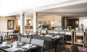a restaurant with tables and chairs and a counter at Family Golf Hotel in Royan