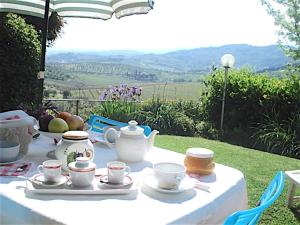 una mesa blanca con teteras y tazas. en La Solaria, en Carmignano