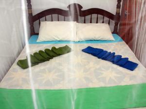 a bed with blue and green pillows on it at Sun Bird Eco Guest Mirissa in Mirissa