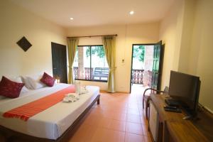 a bedroom with a bed and a flat screen tv at Touch Star Resort - Doi Inthanon in Chom Thong