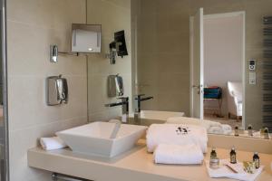 a bathroom with two sinks and a mirror at Hôtel Spa La Cueillette in Meursault
