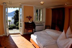 a bedroom with a bed and a balcony at Relais Villa Margherita in Oggebbio
