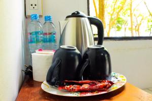 two black tea pots on a plate on a table at Sangthain hills in Ko Samed