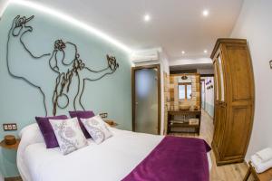 a bedroom with a large bed with purple pillows at Apartament Rural El Rellotge in Sant Mateu