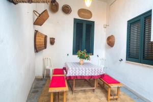 einen Tisch und Stühle in einem Zimmer mit grünen Fenstern in der Unterkunft Appartamento con Piscina in Villa (Galatina) in Galatina