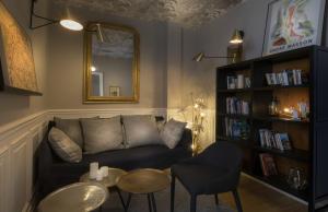 a living room with a couch and a table and a mirror at Hôtel Jeanne d'Arc Le Marais in Paris