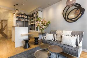a living room with a couch and a table at Hôtel Jeanne d'Arc Le Marais in Paris