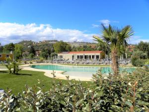 una piscina in un resort con una palma di ReBi Village a Imperia