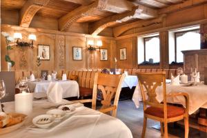 jadalnia ze stołami, krzesłami i oknami w obiekcie Hotel Jesacherhof 4s w mieście Sankt Jakob in Defereggen