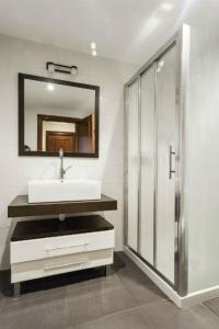 La salle de bains est pourvue d'un lavabo et d'un miroir. dans l'établissement Apartamentos Cotiello, à Llanes