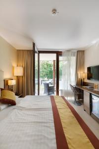 Habitación de hotel con cama grande y TV en Hotel Sacher Baden, en Baden