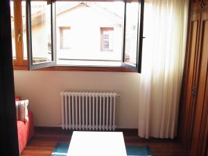 sala de estar con ventana y radiador en Apartamentos Cotiello, en Llanes