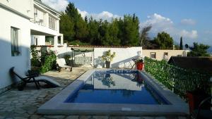 a swimming pool in front of a house at Apartment Tijana in Bar
