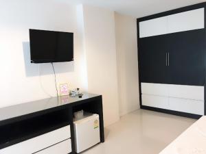 ein Wohnzimmer mit einem TV und einer großen Tür in der Unterkunft Similan Mansion in Bangsaen + 22 Fotos