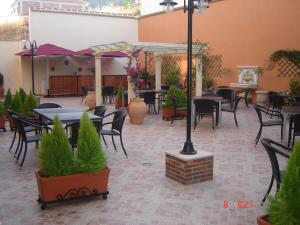 a patio with tables and chairs and plants at Hotel Ciudad de Martos in Martos