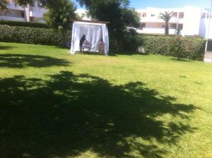 a person sitting in a swing in a yard at Terraço e Mar in Alvor