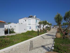 a white house with a pathway in front of it at Blue Beach Villas Apartments in Stavros