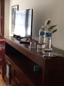 a desk with a computer and two bottles of water at Living Gijon & Parking in Gijón