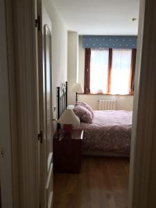 a bedroom with a bed and two lamps on a table at Living Gijon & Parking in Gijón
