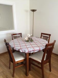 a dining room table with four chairs and a table cloth at Living Gijon & Parking in Gijón