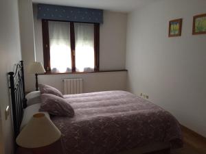 a bedroom with a bed and a window at Living Gijon & Parking in Gijón