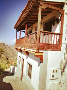 a building with a balcony on the side of it at Alojamientos Nicasio in Tejeda