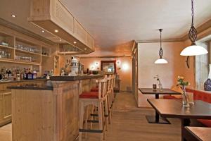 a bar in a restaurant with wooden cabinets and tables at Hotel Anneliese in Bad Hindelang