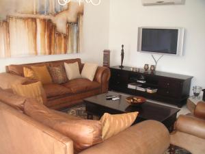 a living room with two couches and a flat screen tv at Waterside Living MM1304 in Jeffreys Bay