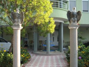 乌尔齐尼Guest House Vila Mimoza的建筑物前有两根石柱的庭院