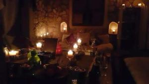 Siwa Relax Retreat Ecolodge في سيوة: غرفة مظلمة مع طاولة عليها الشموع