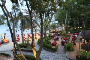 a group of people sitting at tables on the beach at Samed Villa Resort in Ko Samed