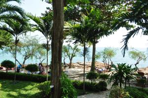 a view of the ocean from a park with palm trees at Samed Villa Resort in Ko Samed
