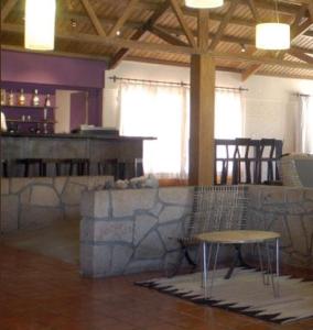 a room with a bar and a table and a stool at Hotel de Las Nubes in San Antonio de los Cobres