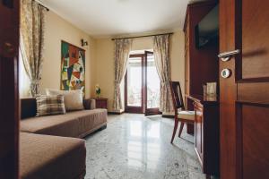 ein Wohnzimmer mit Sofa, Tisch und Fenster in der Unterkunft Carrubba in Tivat