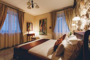 una camera da letto con un letto grande in una stanza con finestre di Carrubba a Tivat