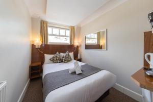 Schlafzimmer mit einem großen weißen Bett und einem Fenster in der Unterkunft Chester Hotel in London