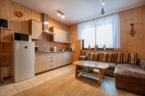 a kitchen and living room with a couch and a table at Dom pod Wilczyńcem in Stronie Śląskie
