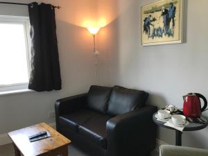 a living room with a black leather couch and a table at The Red Lion Inn in Dittisham