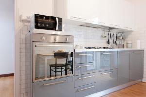 cocina con electrodomésticos de acero inoxidable y mesa en Verona Uptown Mood Apartment, en Verona