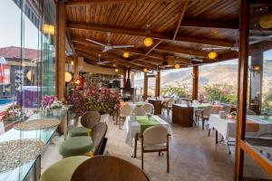 un restaurante con mesas y sillas con montañas al fondo en Villa Sonata, en Alanya