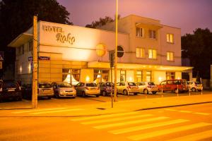 een hotel met auto's die 's nachts op een parkeerplaats geparkeerd staan bij Hotel Roko in Warschau