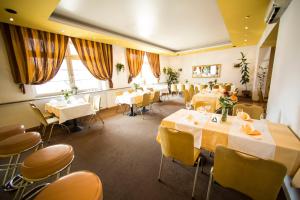 a restaurant with white tables and yellow chairs at Hotel Roko in Warsaw