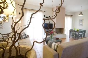 Thalassa Mare Villas في ليغيا: غرفة معيشة بها أريكة وشجرة
