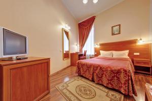 a hotel room with a bed and a flat screen tv at Atria Guest House in Saint Petersburg