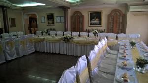 a row of tables in a banquet hall with white chairs at Business Club Selenča in Bač