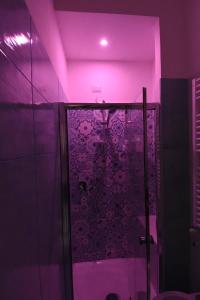 サレルノにあるB&B Cuore di Salernoの紫色の照明付きのシャワー付きのバスルーム