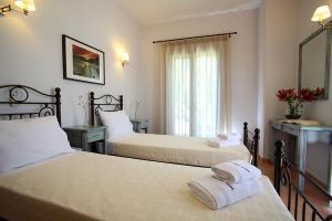 Thalassa Mare Villas في ليغيا: غرفة نوم بسريرين عليها مناشف