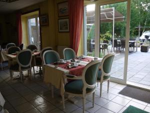 a dining room with tables and chairs and a patio at Hotel Val Saint Hilaire in Givet
