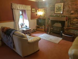 a living room with a couch and a fireplace at Hosefield Bed and Breakfast in Ellon